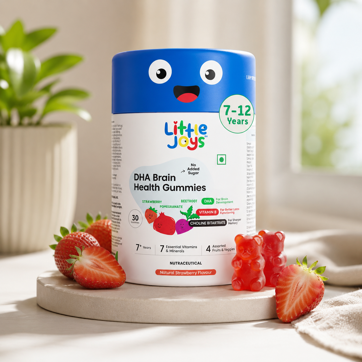 Container of Little Joys DHA Brain Health Gummies for 7-12 years with strawberries on a light background