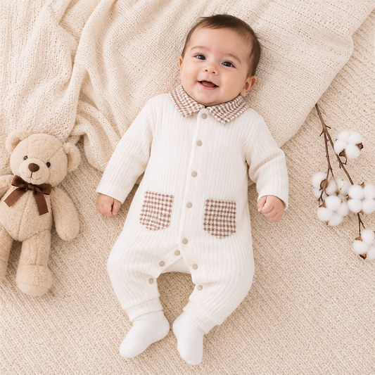 Baby boy wearing cream ribbed romper front view with checked collar and pockets