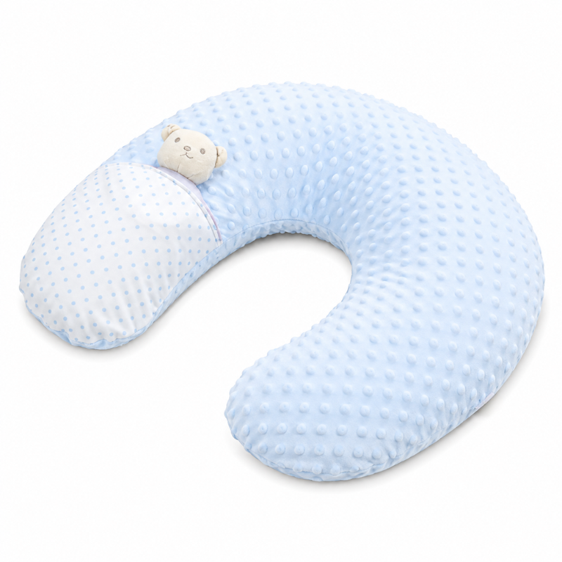 A light blue U-shaped nursing pillow with a textured, dotted fabric on the outside and a smooth, dotted reverse side. A small plush bear face is attached near the top left edge.